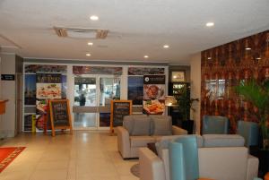 uma loja com sofás e cadeiras num quarto em Airport Gateway Hotel em Auckland