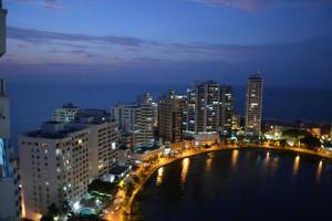 a city skyline at night with a bridge over a body of water at Apartamento Mares de Cartagena in Cartagena de Indias