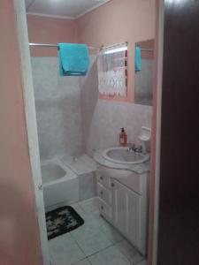 a bathroom with a tub and a sink and a bath tub at Port Antonio Residence in Port Antonio