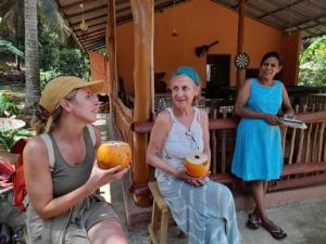 um grupo de mulheres segurando laranjas em frente a um edifício em Morakanda Eco Villa em Elpitiya