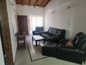 a living room with black leather couches and a table at San Felipe in Las Heras