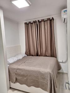 a bedroom with a bed with a brown curtain at Minha Praia Condomínios 2 in Rio de Janeiro