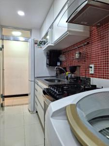 a kitchen with a sink and a stove top oven at Minha Praia Condomínios 2 in Rio de Janeiro