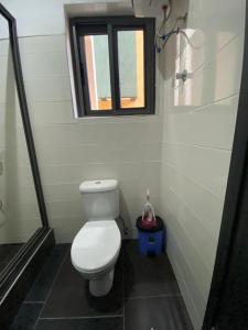 a small bathroom with a toilet and a window at Cozy Lux Apartments by Harolty in Kumasi
