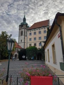 a large building with a clock tower in a courtyard at LEV I SOVA in Mělník