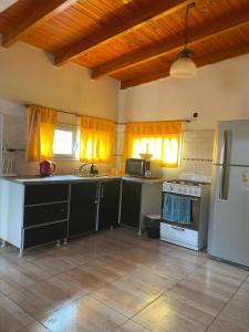 a kitchen with a refrigerator and a stove top oven at ALQUILER X DIA Merlina in Catriel