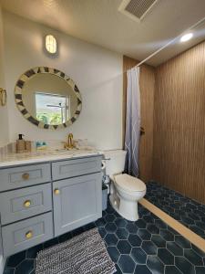y baño con aseo, lavabo y espejo. en Drift House - 4Bed 3Bath Private Pool House, en Cabo Cañaveral