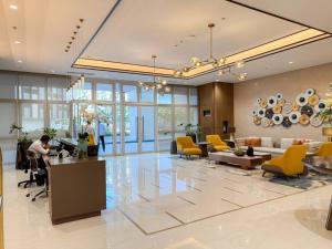 un vestíbulo de un hotel con mesas y sillas amarillas en A2J Luxury 1BR Suite Near Venice Mall BGC Taguig en Manila