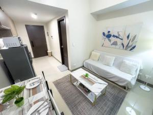 a living room with a white couch and a table at A2J Luxury 1BR Suite Near Venice Mall BGC Taguig in Manila