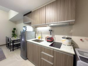 a kitchen with a sink and a refrigerator at A2J Luxury 1BR Suite Near Venice Mall BGC Taguig in Manila