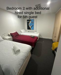 a room with two beds and a sign that reads bedroom with additional hired single at Absolute Beachfront at the Pier Glenelg in Adelaide