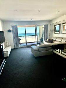 a bedroom with a bed and a view of the ocean at Absolute Beachfront at the Pier Glenelg in Adelaide