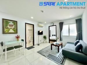 sala de estar con sofá azul y mesa en Sabay Airport Apartment - The Connect, en Ho Chi Minh