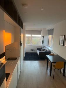 ein Wohnzimmer mit Sofa und Tisch in der Unterkunft Voyager Haus Apartments, EV Charging Stations, London Heathrow Airport, LHR, Terminal 4, RE-Energise & GO in New Bedfont + 68 Fotos