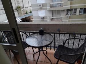 una mesa y sillas en un balcón con vistas a un edificio en Condominio Binacional, en Santana do Livramento