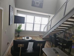 sala de estar con escaleras, mesa y sillas en Fort Worth 2 bedroom Loft Downtown en Fort Worth