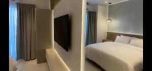une chambre d'hôtel avec un lit et une télévision dans l'établissement The Signature Hotel Apartment Accra Ghana, à Accra