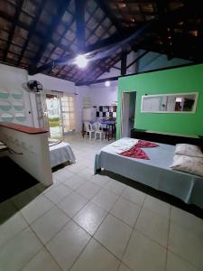 a bedroom with two beds and a green wall at Casa de Temporada das Mangueiras in Olinda