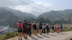 a group of people standing on a road looking at a valley at Bình Bản Liền Homestay 