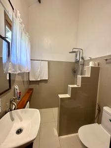 a white bathroom with a sink and a toilet at Isola del Sole Villas and Resort in General Luna