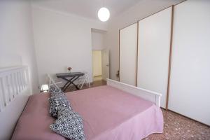 1 dormitorio con cama rosa y mesa en Green Rose Appartamento nel cuore di Roma, en Roma