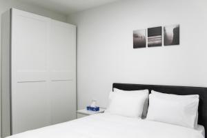 a bedroom with a white bed with white pillows at Luxury Family Apartment #30 By Hashdera Eilat in Eilat