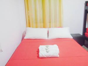 a bed with a red blanket and two white pillows at Central y privado a 1km de la hacienda Nápoles in Doradal +17 photos