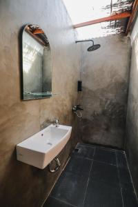 a bathroom with a sink and a mirror at BAMBOO SHACK in Bukittinggi