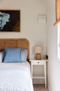 a bedroom with a bed and a table with a lamp at Surf Beach Narooma Holiday Park in Narooma