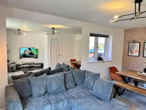 a living room with a blue couch and a table at Luxury Newly Renovated House in Reading