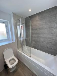 a bathroom with a toilet and a glass shower at Luxury Newly Renovated House in Reading