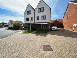 una gran casa blanca con un coche aparcado en la entrada en Luxury Newly Renovated House, en Reading