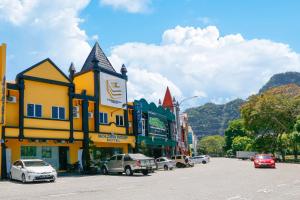 a city street with cars parked in front of buildings at Golden Roof Hotel Sunway Ipoh in Ipoh