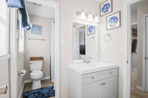 Baño blanco con lavabo y aseo en Charming & Cozy Retreat: Your Perfect RVA Getaway en Richmond