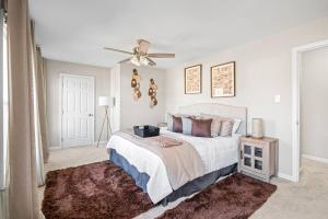 Charming & Cozy Retreat: Your Perfect RVA Getaway في ريتشموند: غرفة نوم بسرير ومروحة سقف