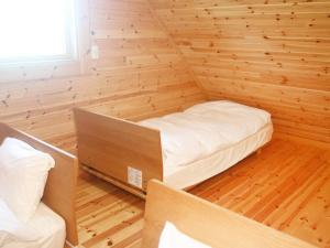 Habitación pequeña con cama en una pared de madera. en 島ログ, en Isla Miyako