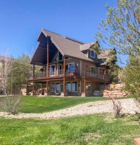 a large house on top of a green lawn at Bear Lake Cabin with Lake Views in Fish Haven