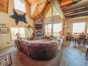 a living room with a large couch and a fireplace at Bear Lake Cabin with Lake Views in Fish Haven