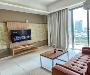The Wisdom Apartment في كوالالمبور: غرفة معيشة مع أريكة وتلفزيون