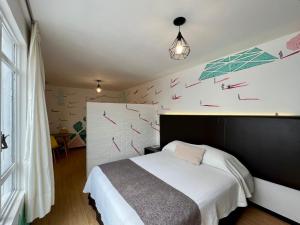 a bedroom with a bed with red arrows on the wall at Suites Havre in Mexico City