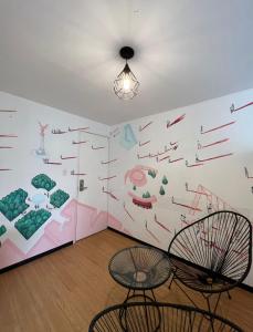 メキシコシティにあるスイート アーブルの椅子2脚とアートが飾られた壁が備わる客室です。