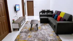 - un salon avec un canapé et une télévision dans l'établissement HomeSTAY PANGSAPURI SAMUDERA SERI MANJUNG LUMUT, à Seri Manjung