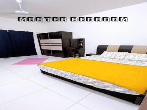 a bedroom with a bed with a yellow blanket at HomeSTAY PANGSAPURI SAMUDERA SERI MANJUNG LUMUT in Seri Manjung