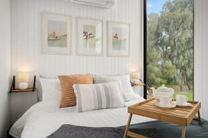 sypialnia z białym łóżkiem i stołem w obiekcie Tiny Charm w mieście Lake Charm