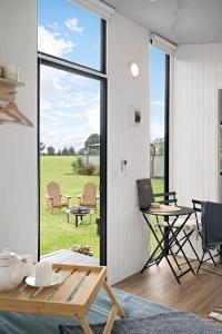 a living room with a table and a sliding glass door at Tiny Charm in Lake Charm