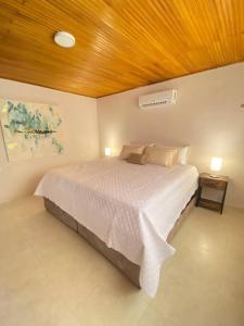 1 dormitorio con cama blanca y techo de madera en Apto Valle Suites, La Mejor Zona en Valledupar