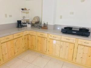 a kitchen with wooden cabinets and a counter top at RAYAS Guesthouse- No Credit Card Needed in Baguio