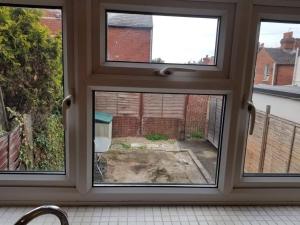 a window with a view of a yard at Central Reading 4 Bedrooms 2Baths Free Parking in Reading