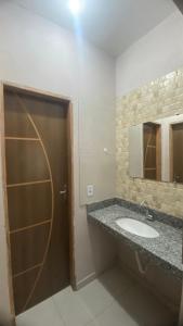 La salle de bains est pourvue d'un lavabo et d'un miroir. dans l'établissement Casa Azul do Capão, à Palmeiras
