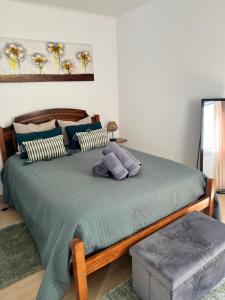 a bedroom with a bed with a green comforter at Casa da Cascata do Segredo in Praia